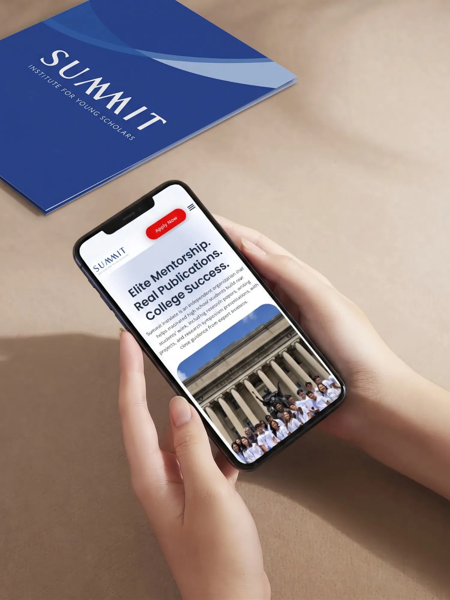 Hands holding a phone showing the Summit Institute mobile homepage, with the blue Summit presentation folder on the table behind.