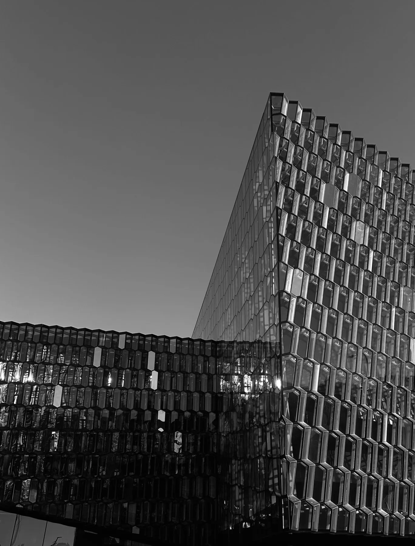 Black and white photo of a glass building with a honeycomb facade.
