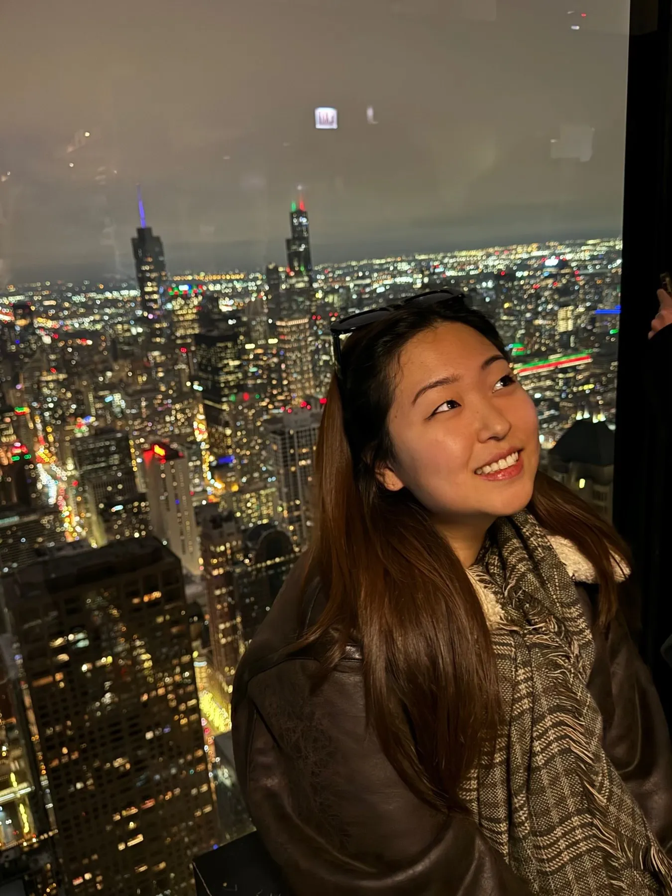 Christine looking out over a city skyline at night.